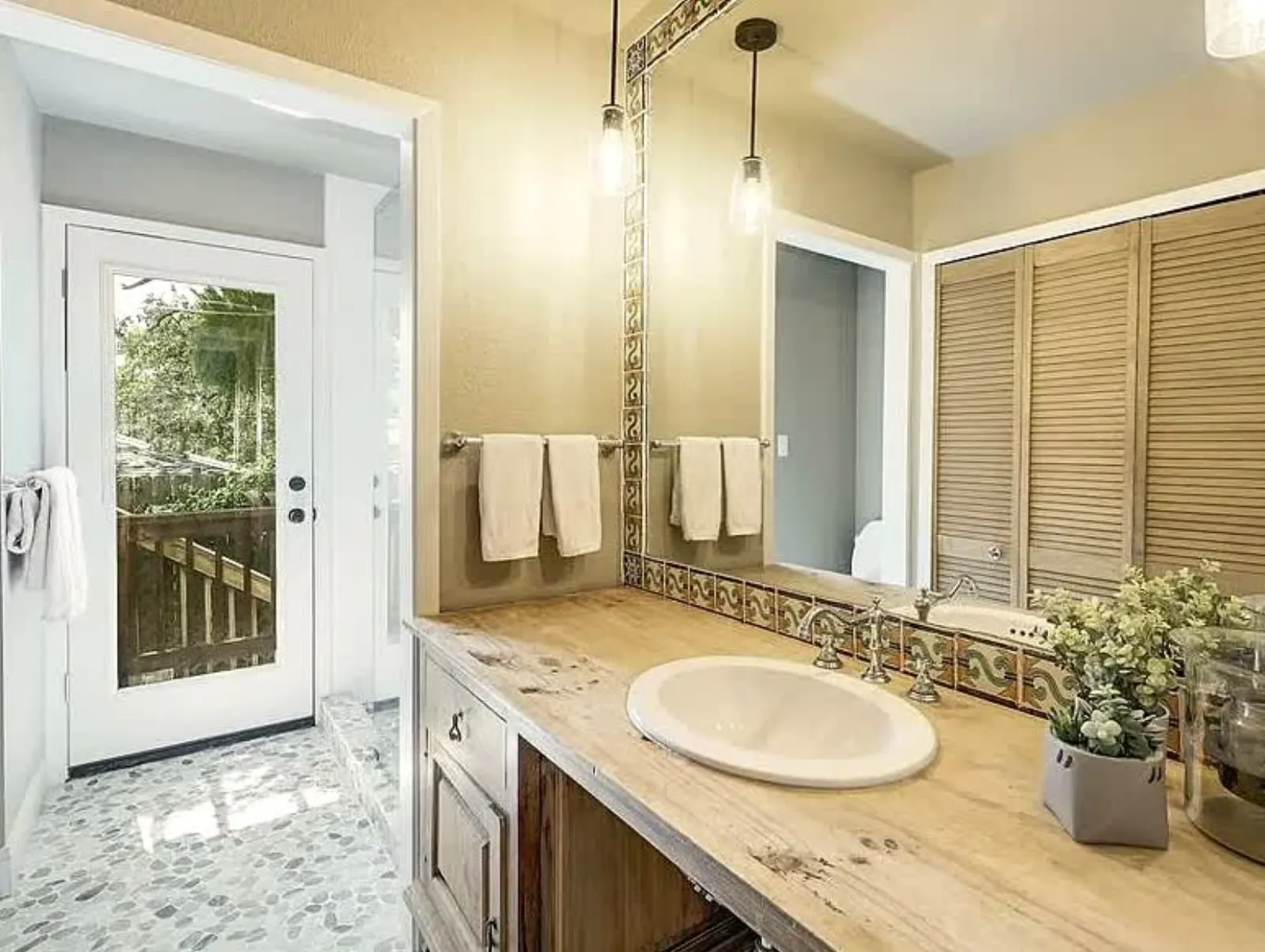 Bathroom vanity with wood countertop and tile backsplash
