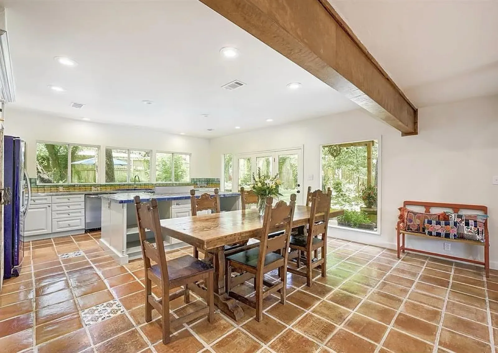 Open kitchen with terracotta tile floor and wood beam