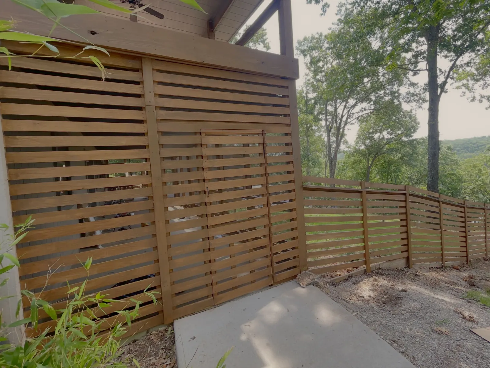 Horizontal slat wood fence and stained deck