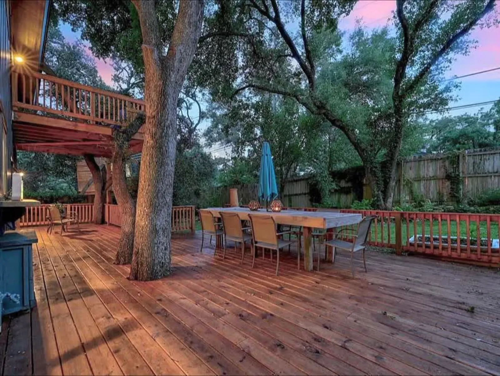 Stained deck balcony with evening dining area under trees