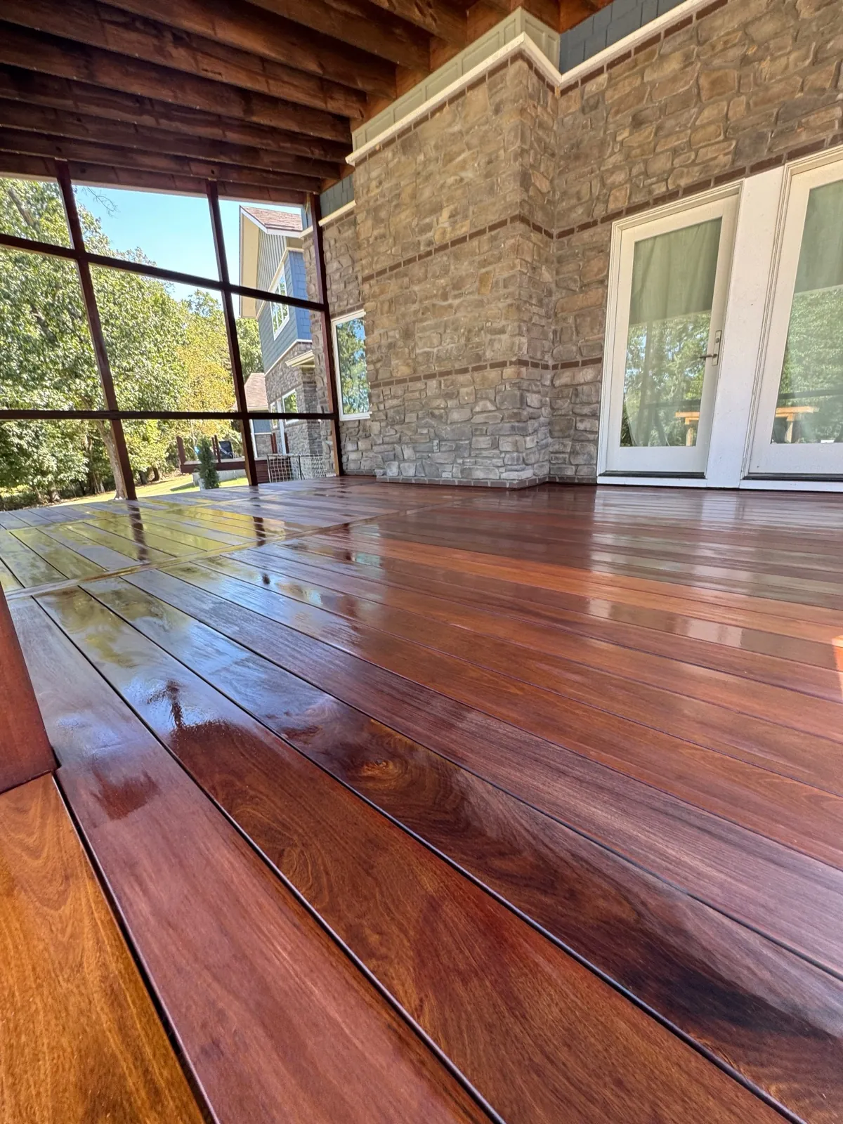 Screened porch with stone chimney and French doors