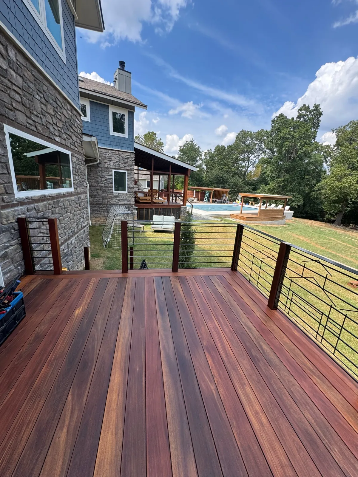 Cable rail ipe deck at a stone house with pool below