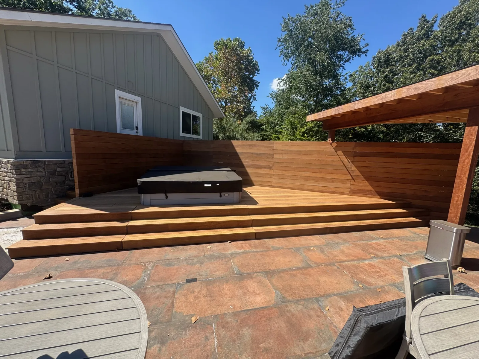 Cedar privacy wall with hot tub, pergola, and tile patio