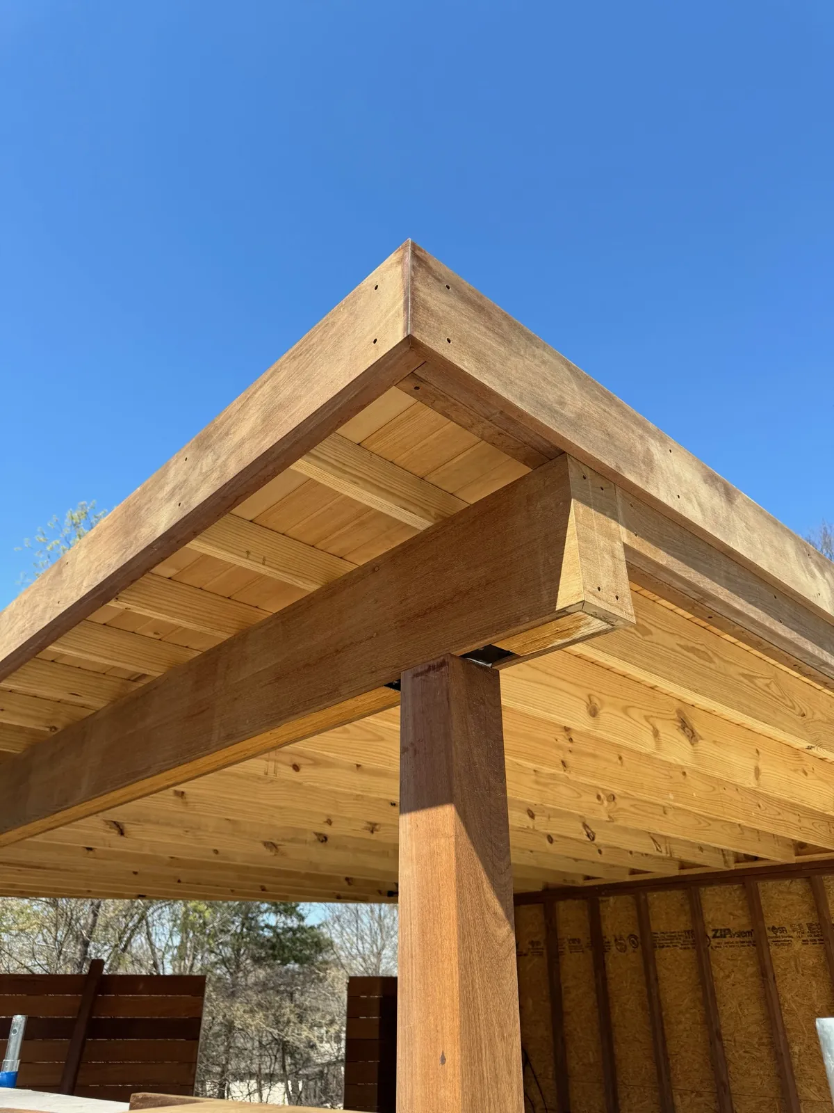 Wood pergola corner post and beam against blue sky