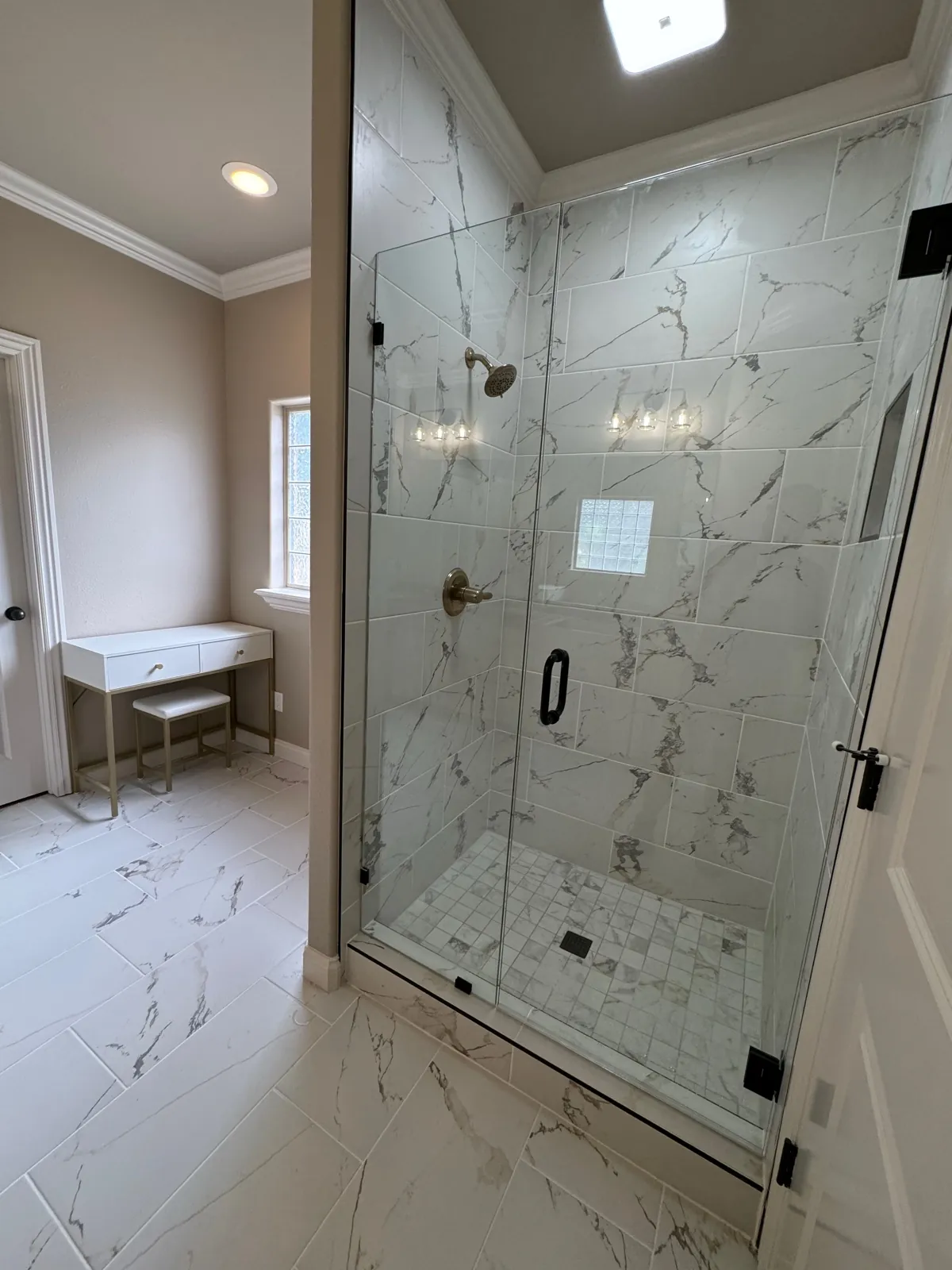 Marble tiled shower with vanity beyond
