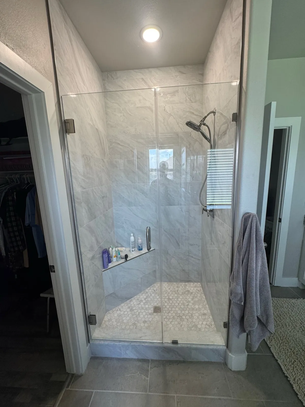 Frameless glass shower with marble tile