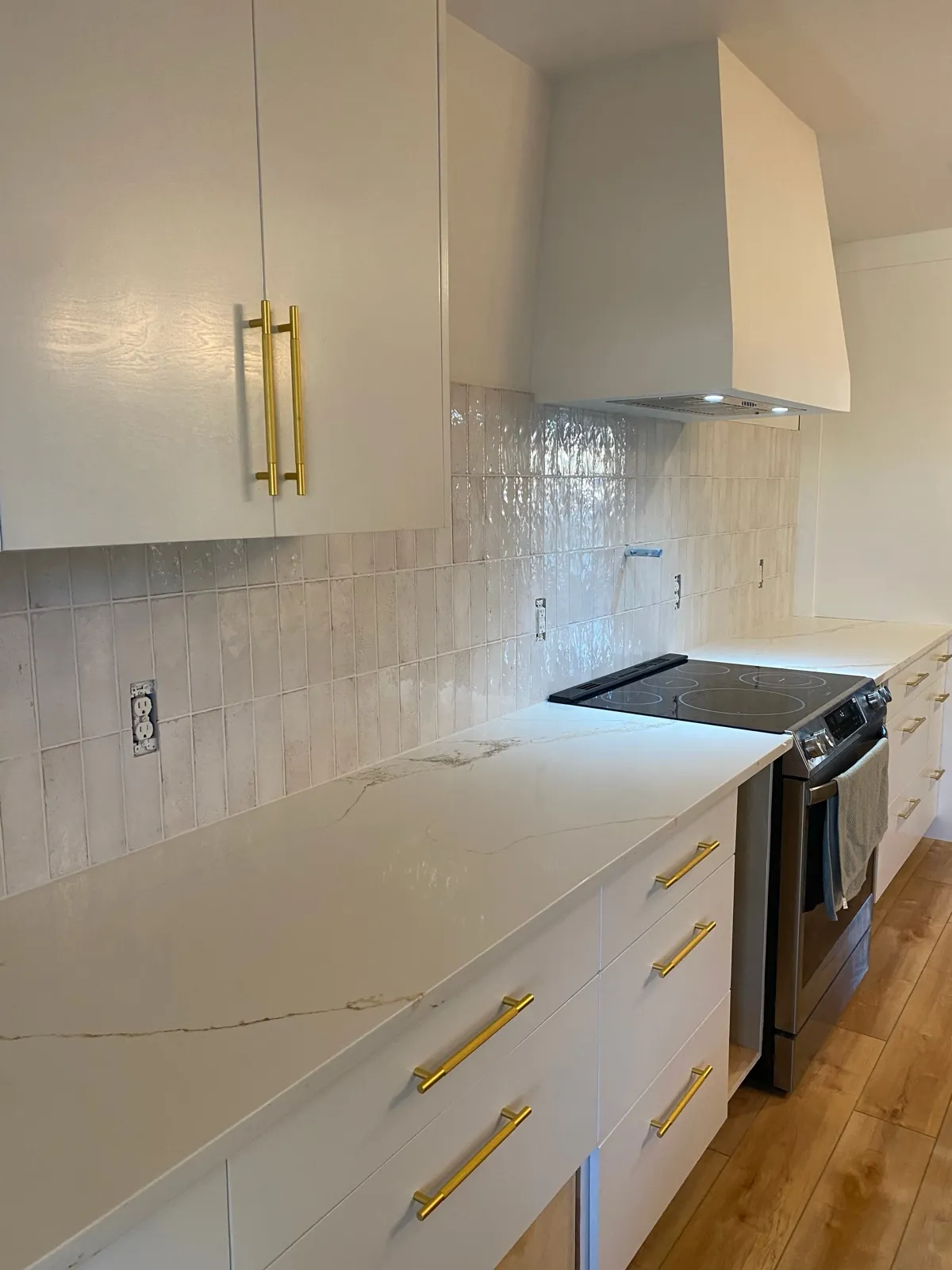 Wave textured tile backsplash with gold hardware